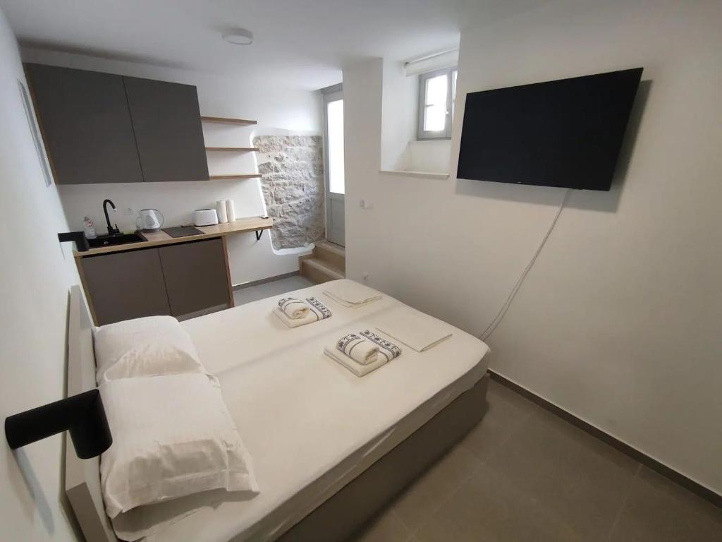 a small room with a bed and a television at The center of Split, renovated stone house in Split
