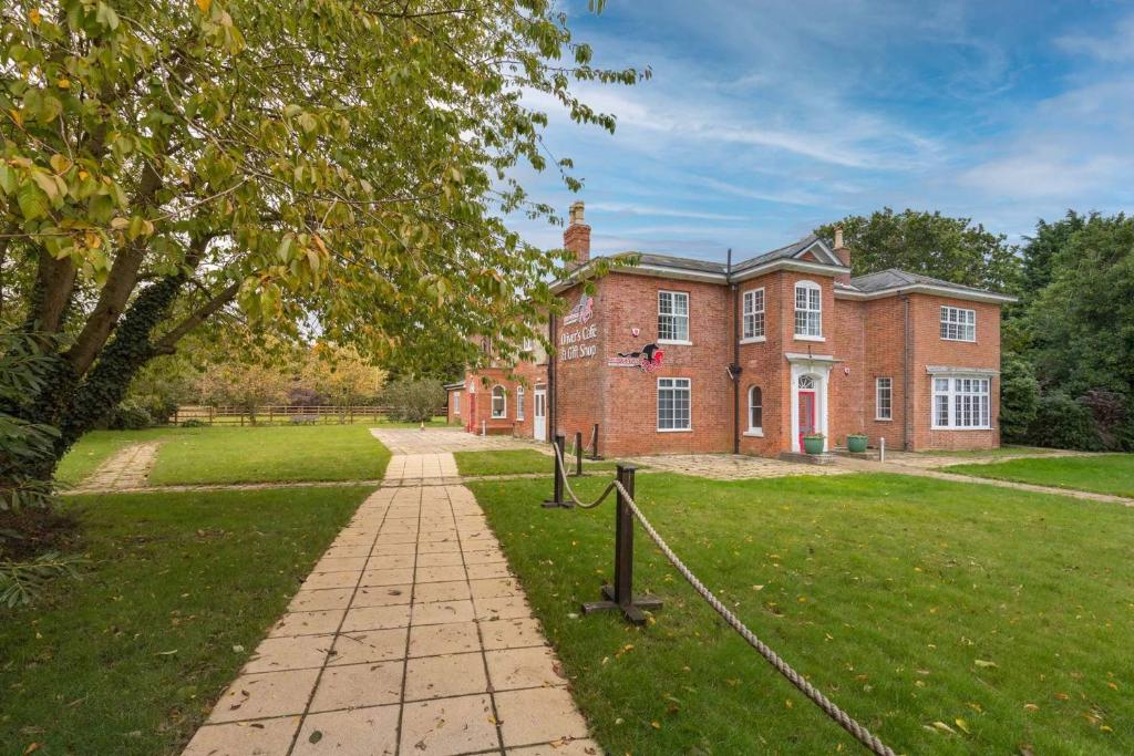 a brick building with a pathway in front of it at Redwings Sanctuary Rooms - Norfolk Holiday Properties 