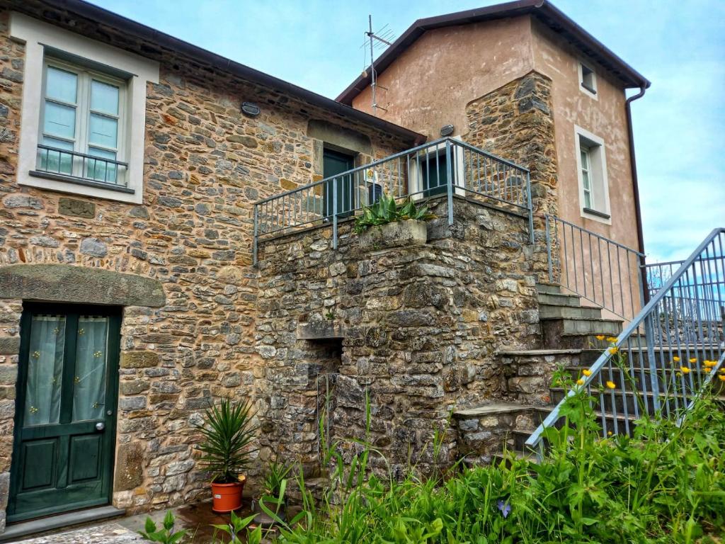 an old stone house with a green door and stairs at Casa Natale in Monterosso al Mare