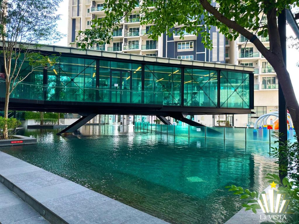 a glass bridge over a river in a city at The Shore Hotel & Residences By Lá VISTA in Melaka
