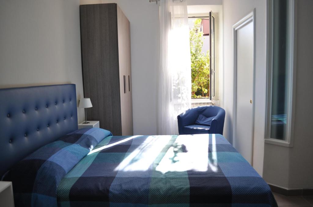 a bedroom with a bed and a chair and a window at Il Giardinetto in Civitavecchia