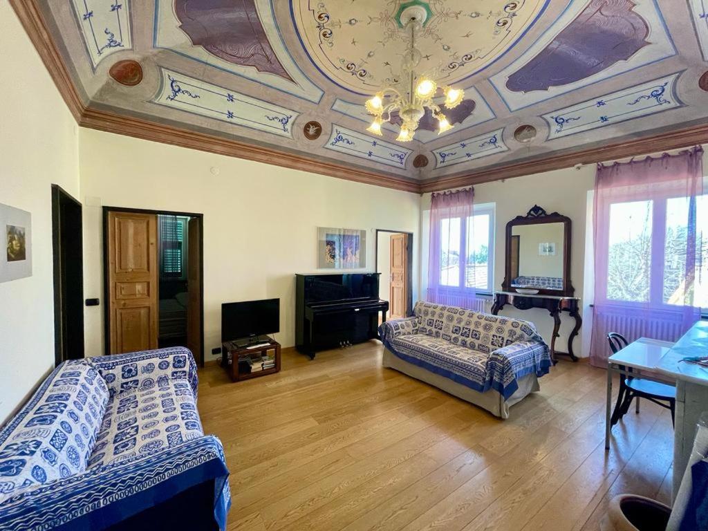 un soggiorno con soffitto a cassettoni e una camera con due letti di Viola apartment, Levanto - 5 Terre a Levanto