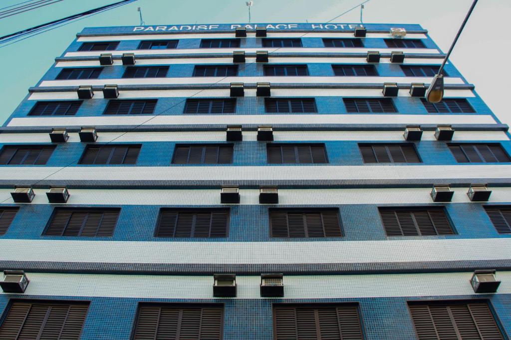 un edificio alto azul con un letrero. en Paradise Palace Hotel en Aparecida