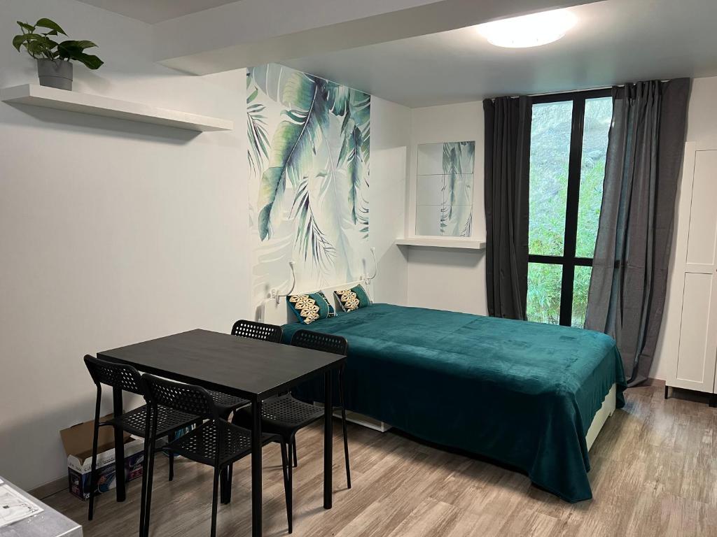 een slaapkamer met een bed, een tafel en een raam bij Carry centre au calme in Carry-le-Rouet