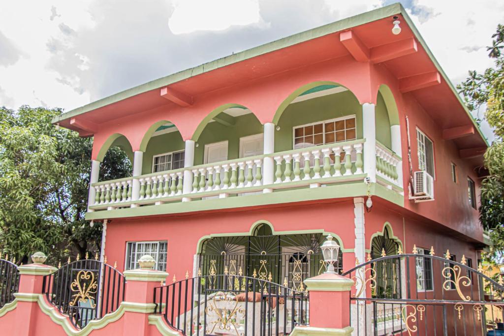 a pink house with a balcony on top of it at Charlie's Cottages in Negril