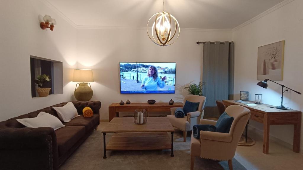sala de estar con sofá y TV en la pared en Casa Isabel, en Betancuria