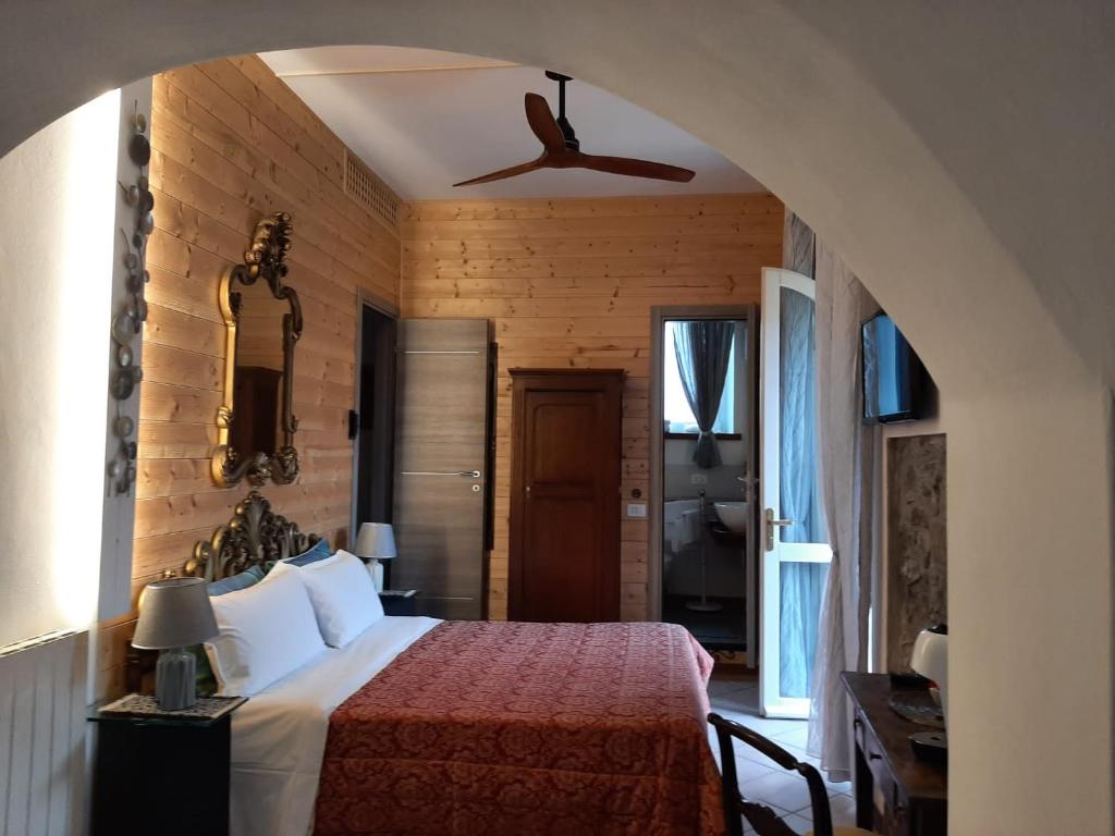 1 dormitorio con 1 cama y ventilador de techo en La Villa, en La Spezia