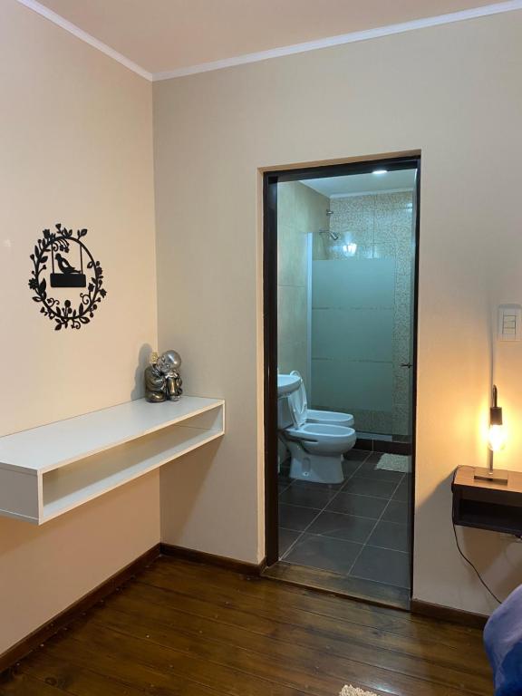 a bathroom with a toilet and a glass shower at Caseros 139 in General Alvear