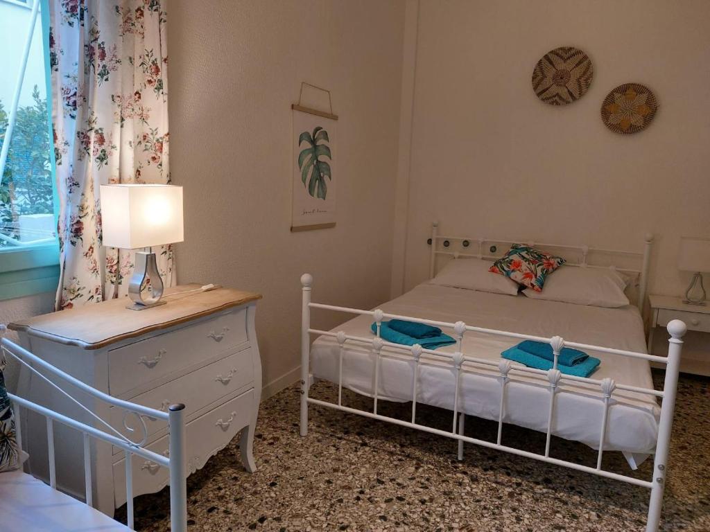 a bedroom with a bed and a dresser and a lamp at Vitamin sea Studio in Panayía