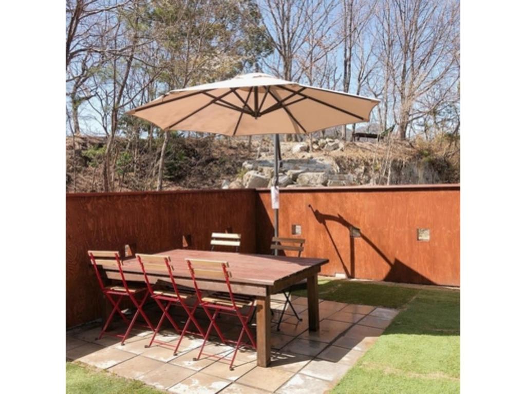 uma mesa de madeira e cadeiras com um guarda-sol em Sunset Village - Vacation STAY 15318v em Onomichi