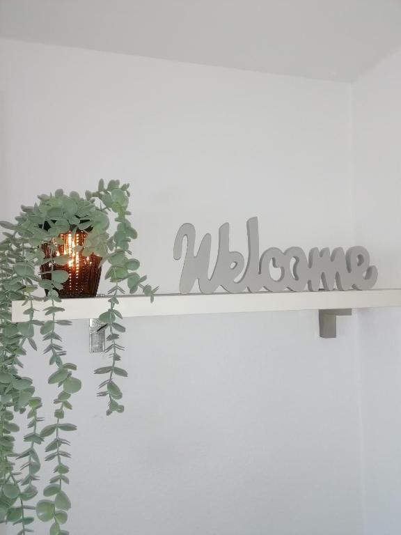 a shelf with a plant and a sign that reads welcome at Ferienwohnung III Sarrebriese in Bottmersdorf