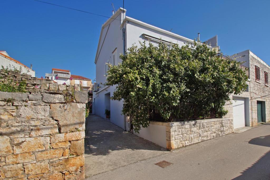 a brick building with a tree on the side of it at Apartman Bačić in Vela Luka