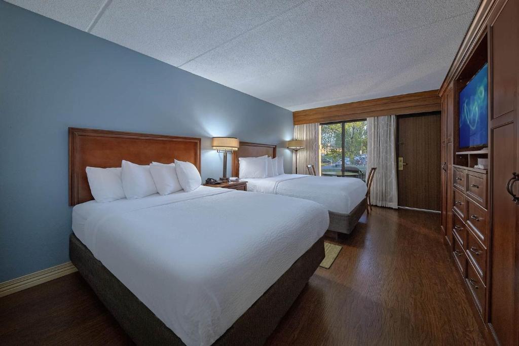 a hotel room with two beds and a television at The Inn On The River in Pigeon Forge