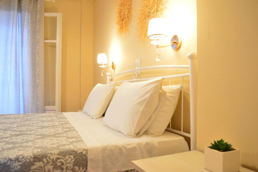 ein Schlafzimmer mit einem Bett mit weißen Kissen in der Unterkunft Αndreas Studios in Ýpsos