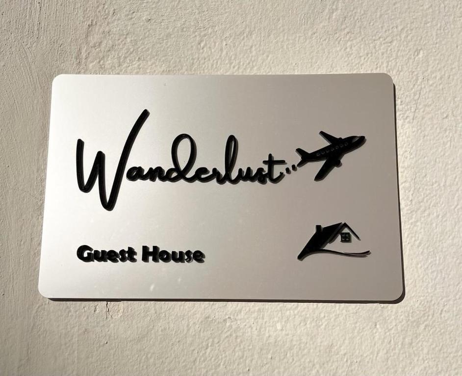 a sign on a wall with a plane on it at Wanderlust Guesthouse in Lamezia Terme