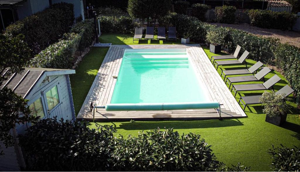 einen Blick über einen Pool mit Liegestühlen und Gras in der Unterkunft Chez Muriel in Porto-Vecchio