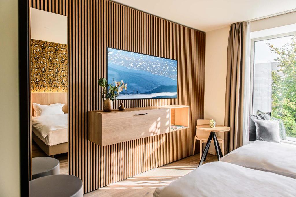 a bedroom with a bed and a tv on a wall at Afterwork Hotel in Etoy