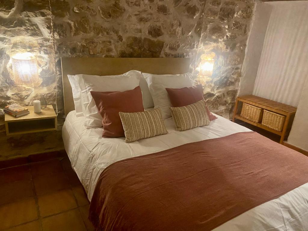 a bedroom with a large bed with two pillows at Posada de Lola in El Molar