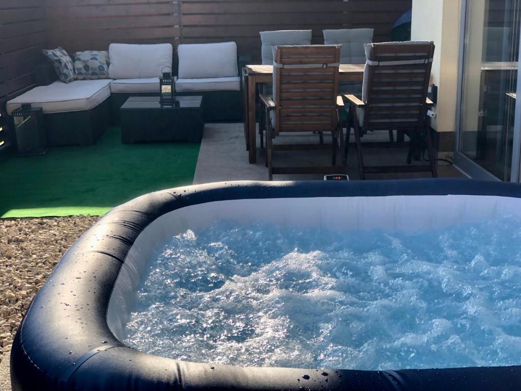 une grande baignoire remplie d'eau à côté d'une terrasse dans l'établissement Jenny Apartment with Jacuzzi, à Brezovica