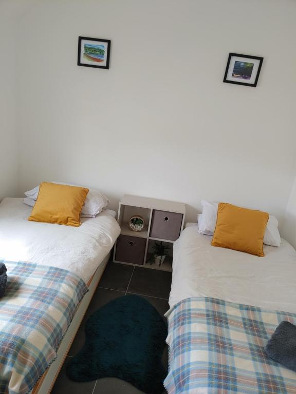 dos camas sentadas una al lado de la otra en una habitación en Cosy 2 Bedroom Croft Cottage with Beautiful Views, en North Kessock
