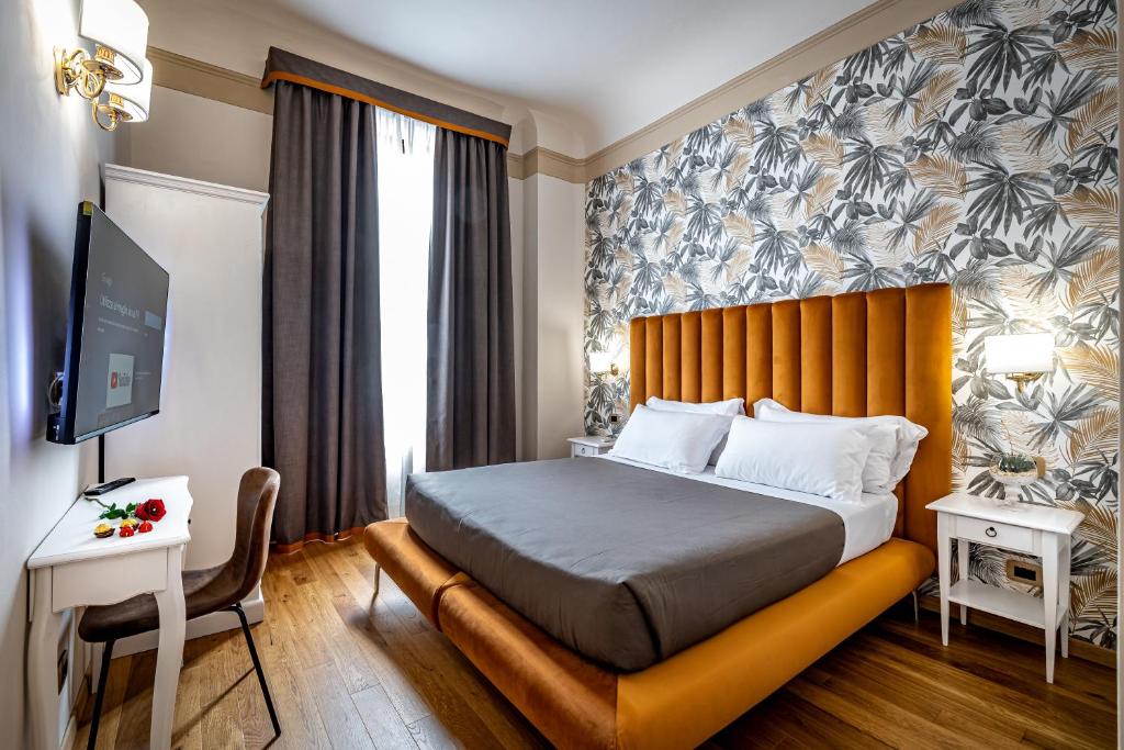 a hotel room with a bed and a tv at Maison Pitti Florence in Florence