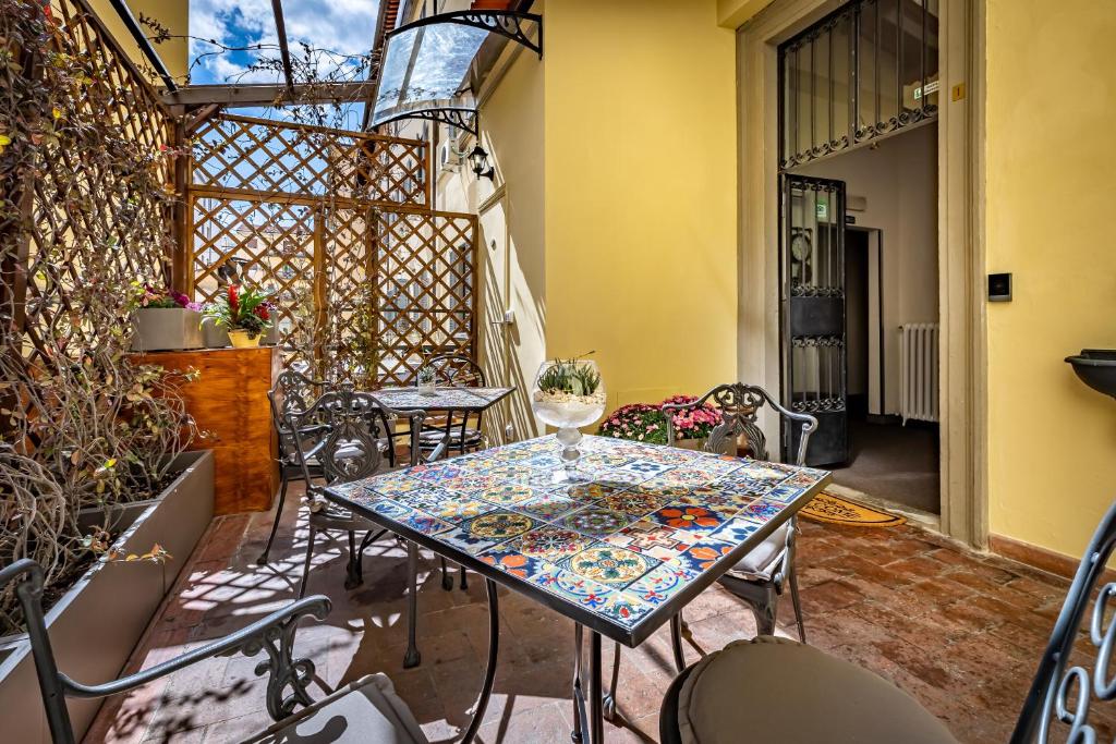 patio ze stołem i krzesłami na patio w obiekcie Maison Pitti Florence we Florencji