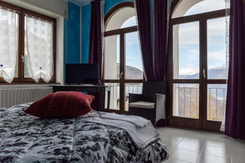 um quarto com janelas e uma cama com uma almofada em Locanda Cà Priula em Albaredo per San Marco