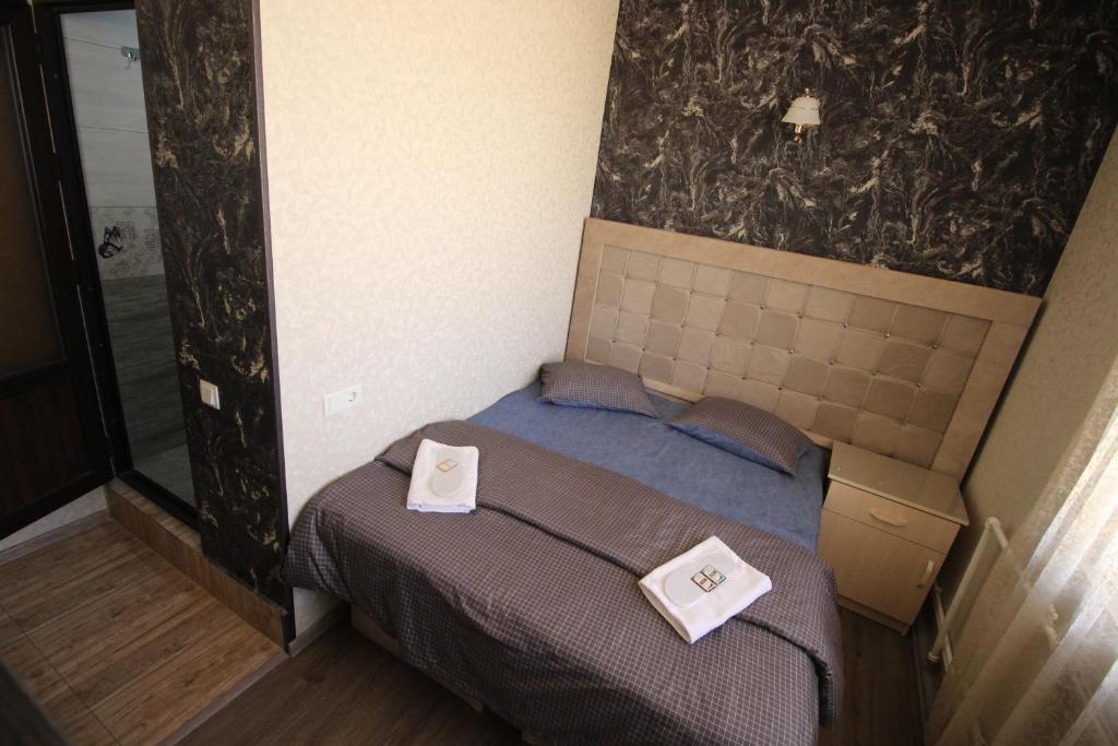 1 dormitorio con 1 cama con 2 toallas en Oazis, en Noratus
