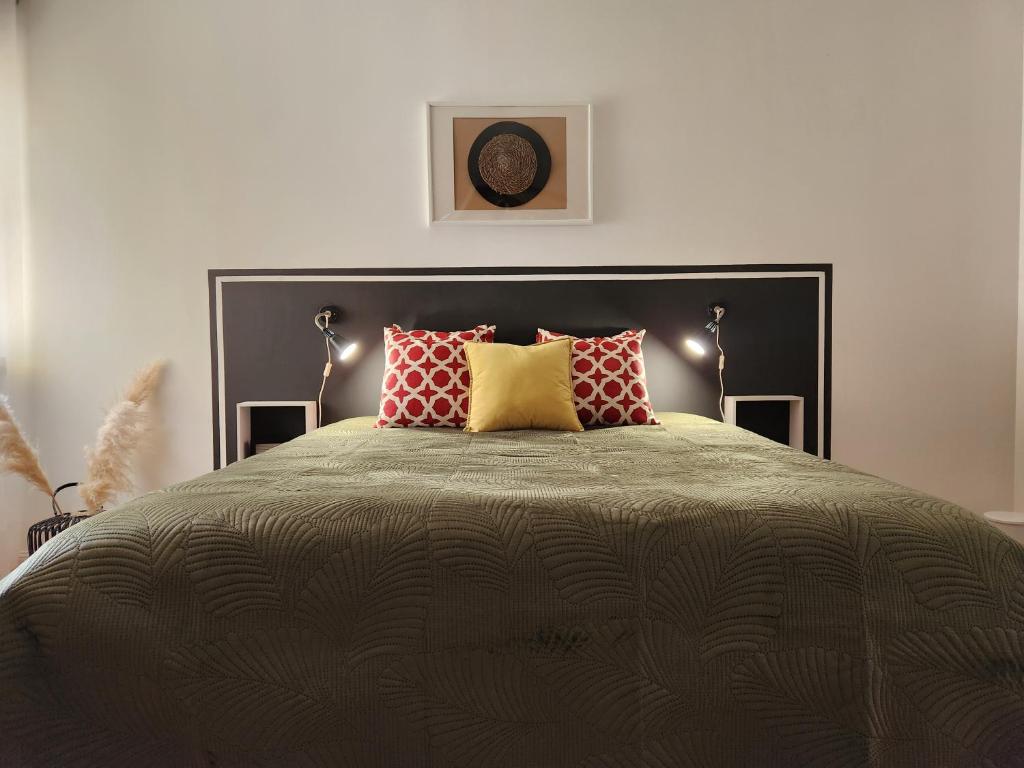 a bedroom with a large bed with red and yellow pillows at Cozy Island Apartment II RAAL 2162 in Lagoa