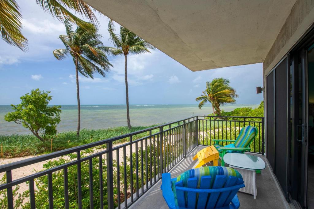 balkon z 2 krzesłami i stołem oraz widokiem na ocean w obiekcie Mar Y Sol Ocean Front w mieście Key West