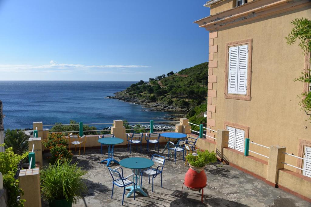 卡尼亞諾的住宿－尤帕特利亞庫酒店，一个带桌椅的庭院,俯瞰着大海