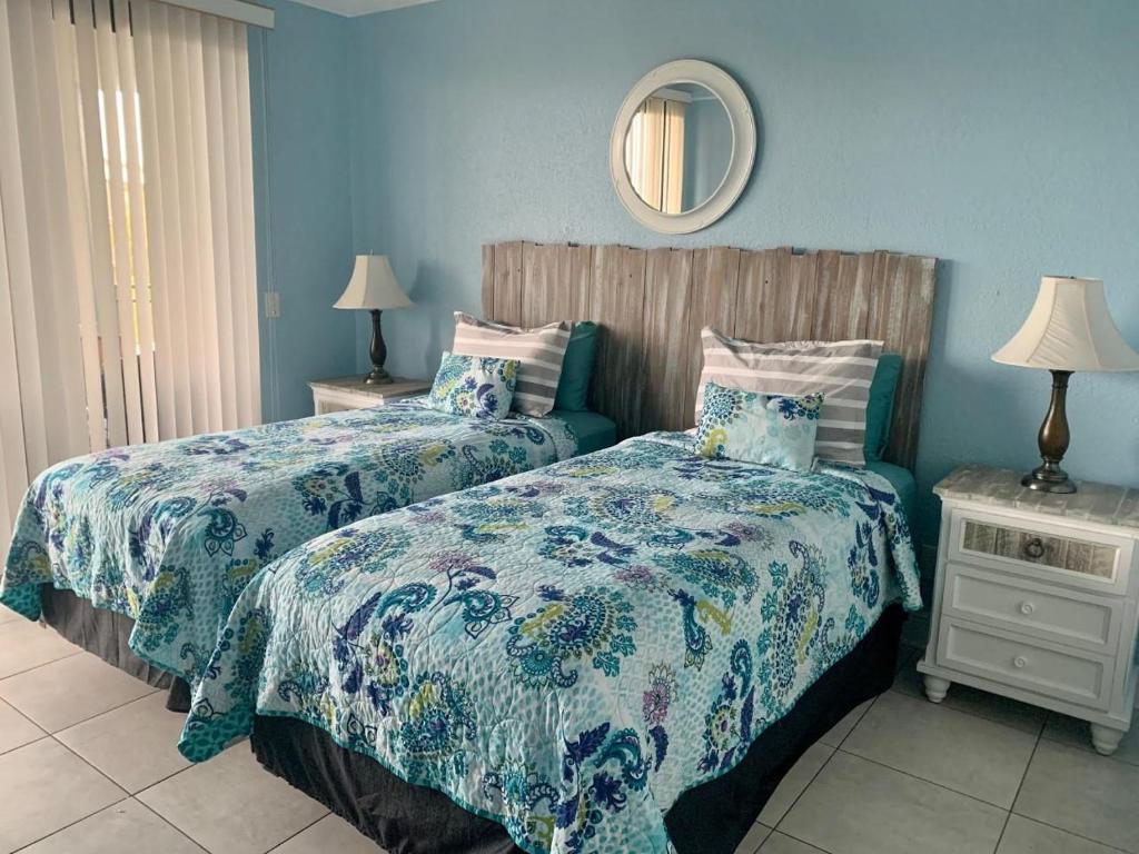 a bedroom with two beds and a mirror on the wall at Sunrise on the Atlantic in Key West