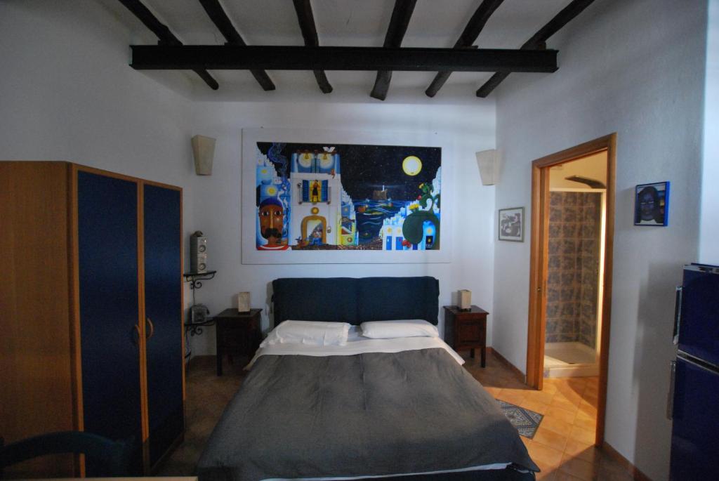 リーパリにあるLipari Studio Old Townのベッドルーム1室(ベッド1台付)が備わります。壁には絵画が飾られています。