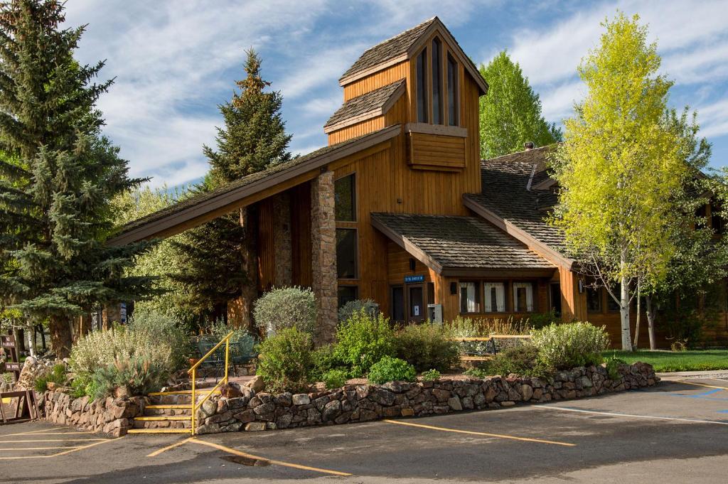 ein großes Holzhaus mit einer Steinmauer in der Unterkunft Thousand Trails Blue Mesa Recreational Ranch in Hierro