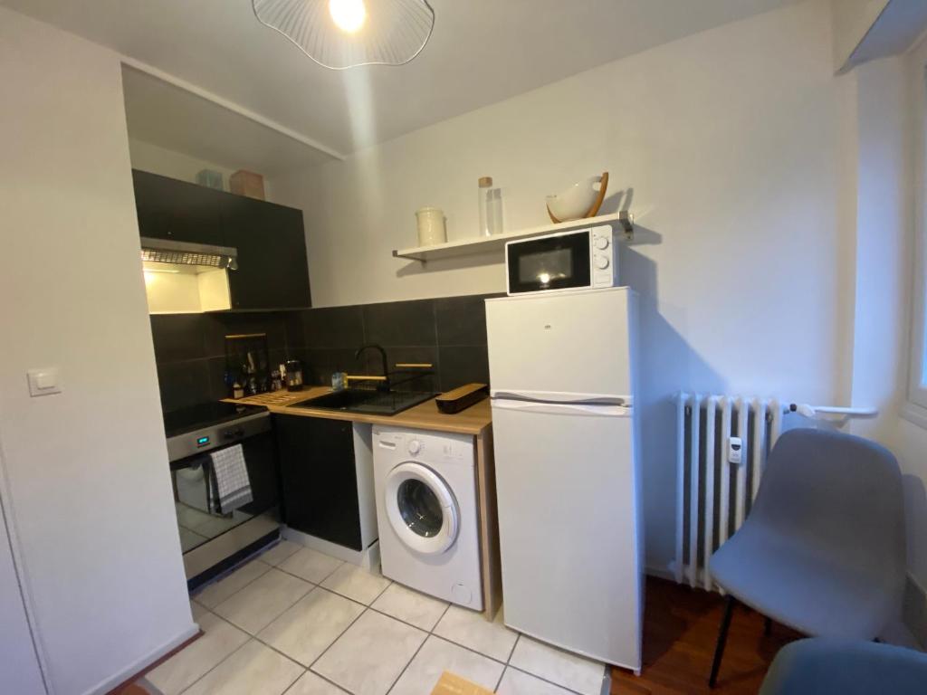 a kitchen with a washing machine and a washer at Cosy F2 Royat Thermes in Royat