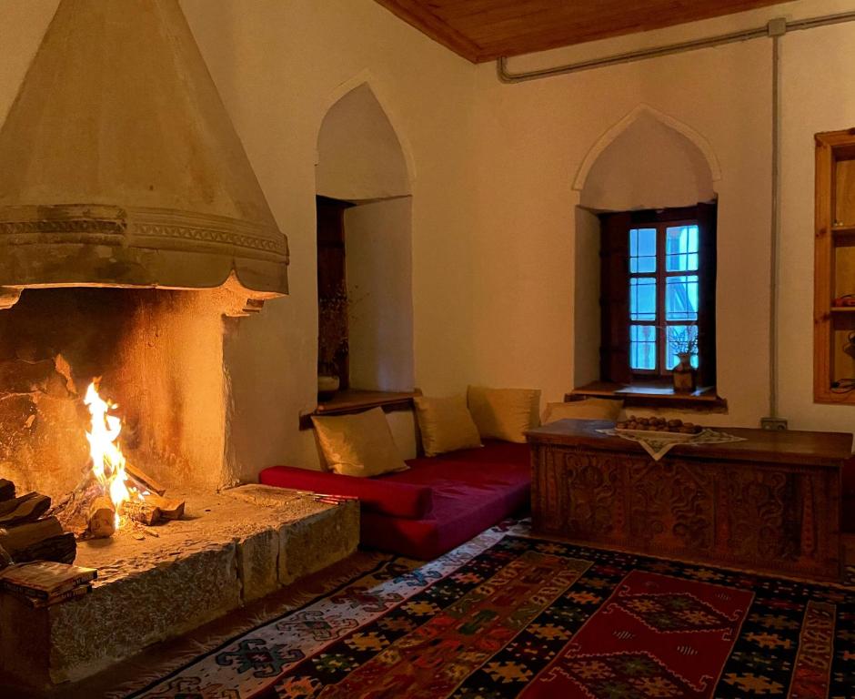 StolacにあるNational monument Mehmedbasica Kucaのリビングルーム(暖炉、赤いソファ付)