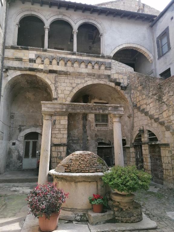 an old stone building with a fountain in front of it at Casa del Palazzo del Marchese in Tarquinia