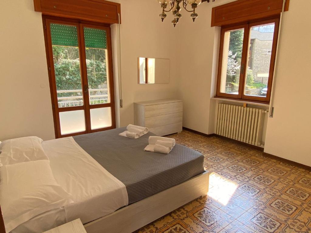 a bedroom with a bed and two windows at Appartamento al Centro Storico di San Marino in San Marino