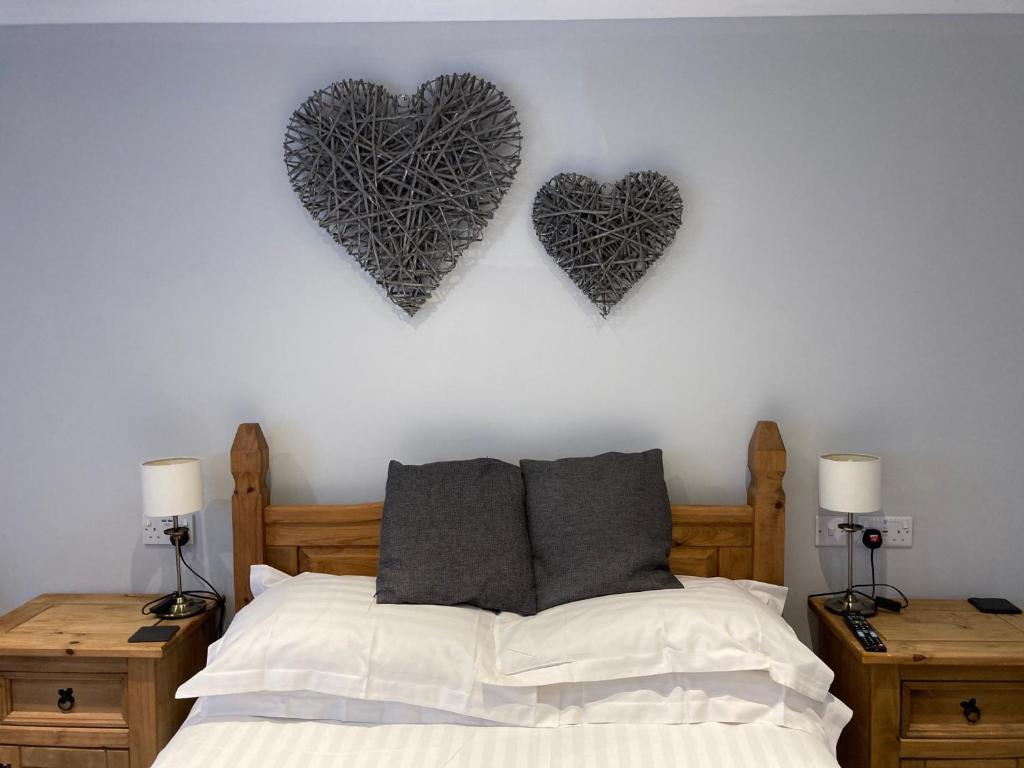 two hearts hanging on a wall above a bed at Wicks at 26 in Sandown