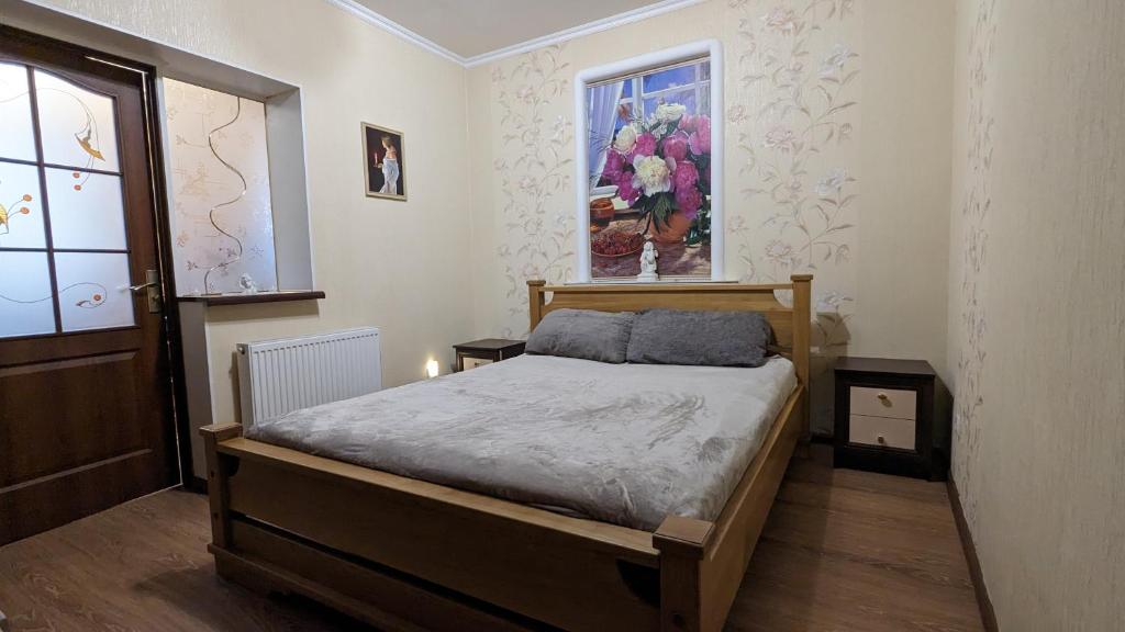 um quarto com uma cama e um quadro na parede em TownHouse Euro жд вокзал, фонтан, чеки ПРРО em Vinnytsya