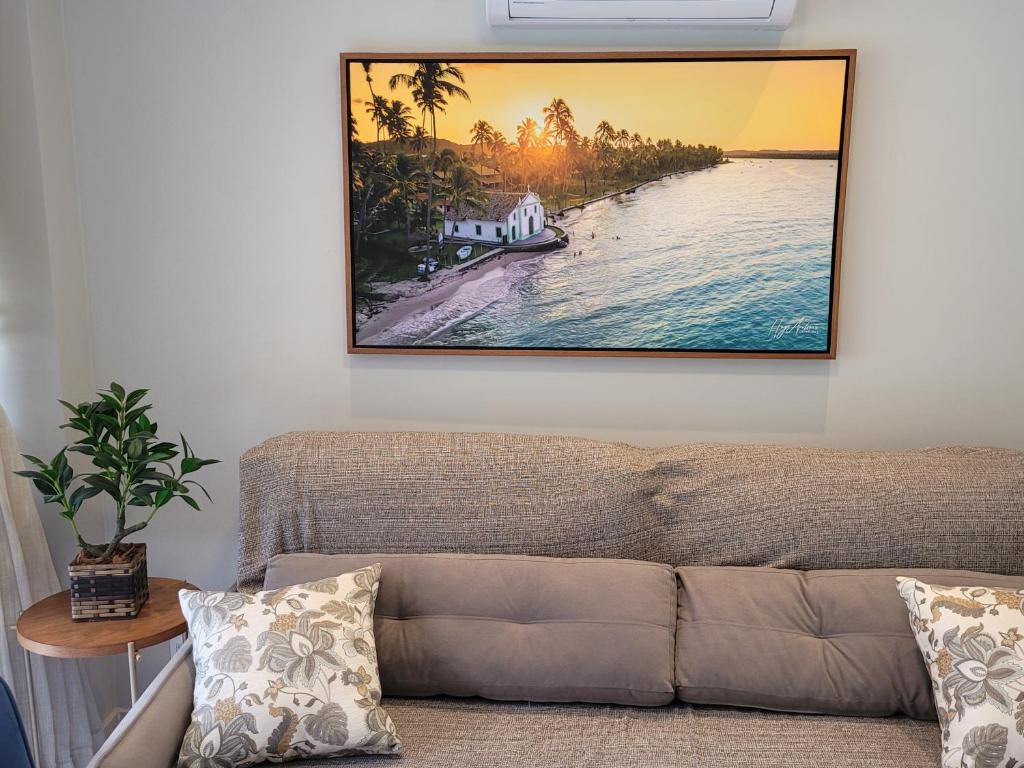 a living room with a couch and a picture on the wall at Praia dos Carneiros Flat 120-CM Eco Resort - ao lado da igrejinha in Tamandaré