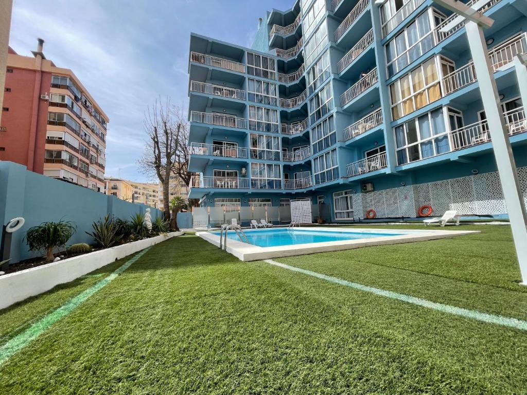 een groot appartementencomplex met een zwembad en een tuin bij Piso de una habitación en Torremolinos in Torremolinos