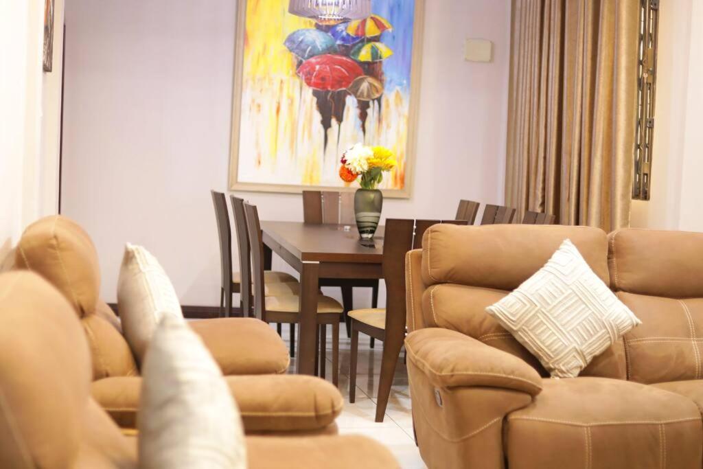 a living room with a table and chairs and a dining room at Spacious 3BR Apartment in Ghana Jeffston Court Prime Stay in Accra in Accra