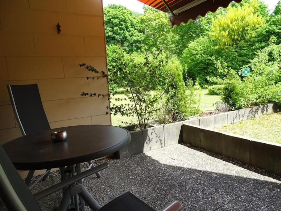 a table and chairs on a patio with a view of a yard at Geschäfts- und Ferienwohnung 111 in Bad Urach