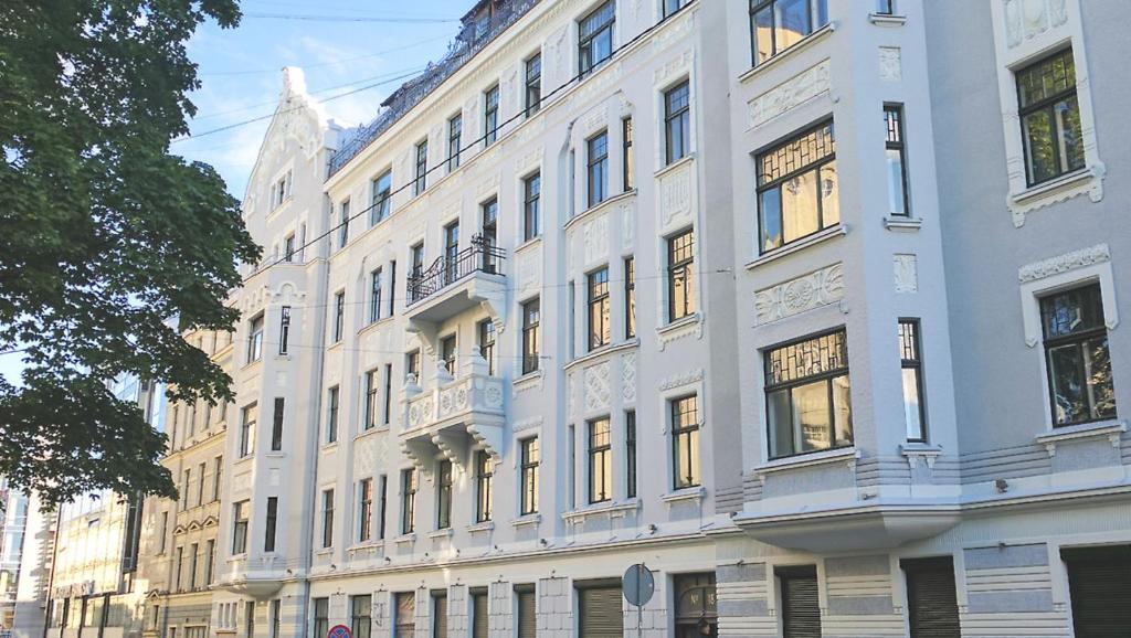 a large white building with a lot of windows at Julia Lacplesa Apartments in Rīga