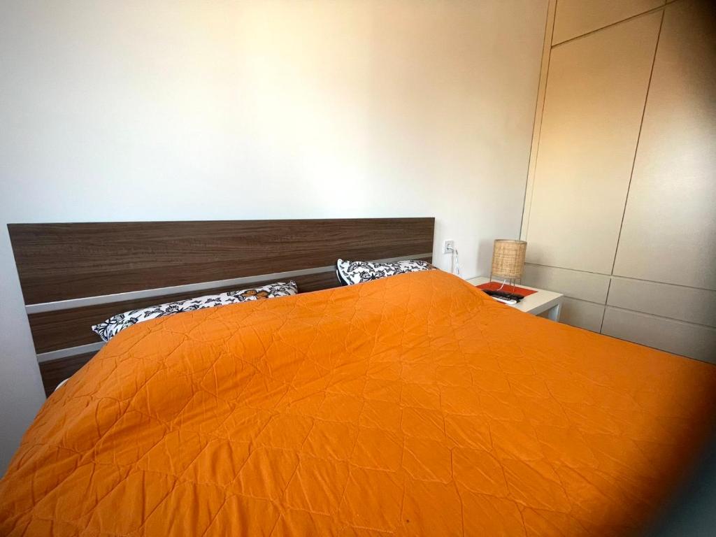 Apartman Nikol في كومانوفو: غرفة نوم بسرير برتقالي في غرفة