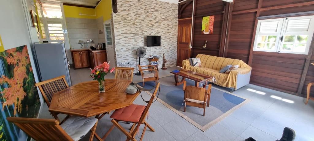 sala de estar con mesa, sillas y sofá en le temps d'une île, en Grand-Bourg