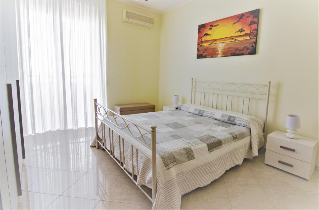 a bedroom with a bed and a large window at Cielo Stellato in Polignano a Mare