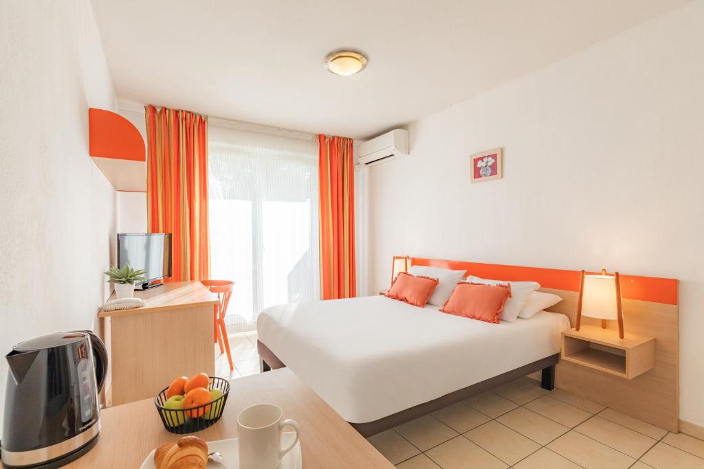 エクス・アン・プロヴァンスにあるAppart'City Classic Aix-en-Provence - La Duranneのベッド、デスク、テレビが備わるホテルルームです。