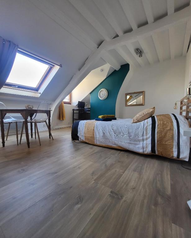 翁弗勒爾的住宿－Les Z'amours，阁楼上的卧室配有床和桌子